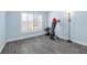 Exercise room with light blue walls, gray laminate flooring, large window with blinds, and weight lifting equipment at 145 Circle Hill Rd, Sanford, FL 32773