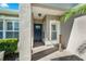 Covered front porch with decorative columns, tile flooring and a blue front door at 145 Circle Hill Rd, Sanford, FL 32773
