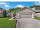 Charming home featuring a two-car garage, well-kept lawn, and decorative shrubbery at 145 Circle Hill Rd, Sanford, FL 32773