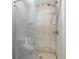 An enclosed tiled shower featuring a glass door, shower head, built-in shelf, and gray tile flooring at 145 Circle Hill Rd, Sanford, FL 32773