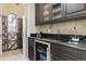 Convenient bar area features dark wood cabinets, granite counters, and a wine fridge, perfect for entertaining at 14700 Avenue Of The Rushes, Winter Garden, FL 34787