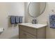 Comfortable half-bathroom with a modern design, with navy and white colored hand towels at 14700 Avenue Of The Rushes, Winter Garden, FL 34787