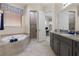 Well-lit bathroom boasts a soaking tub, walk-in shower, dark cabinets and decorative granite countertop at 14700 Avenue Of The Rushes, Winter Garden, FL 34787
