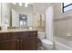Well-lit bathroom with tiled walls, dark wood vanity, granite countertop, and shower-tub combination at 14700 Avenue Of The Rushes, Winter Garden, FL 34787