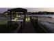 Beautiful dusk view of the covered dock with boat lift and seating at 14700 Avenue Of The Rushes, Winter Garden, FL 34787