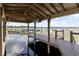 Covered boat dock featuring a boat lift, and two chairs on the end overlooking the lake at 14700 Avenue Of The Rushes, Winter Garden, FL 34787