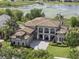 Elegant home featuring a tile roof, manicured lawn, and arched entryway, with lake views at 14700 Avenue Of The Rushes, Winter Garden, FL 34787