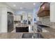 Open kitchen with large island, custom range hood, and stainless steel appliances at 14700 Avenue Of The Rushes, Winter Garden, FL 34787