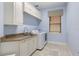 Bright laundry room with overhead cabinets, granite countertop and tile floor at 14700 Avenue Of The Rushes, Winter Garden, FL 34787