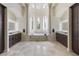 Luxurious main bathroom featuring dual vanities, a soaking tub, and elegant architectural details, creating a spa-like experience at 14700 Avenue Of The Rushes, Winter Garden, FL 34787