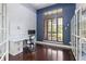 Bright home office featuring hardwood floors, built-in shelves, and a large window overlooking the landscaped yard at 14700 Avenue Of The Rushes, Winter Garden, FL 34787