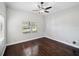 Cozy bedroom with hardwood floors, ceiling fan, and windows offering natural light at 148 Oak View Cir, Lake Mary, FL 32746