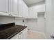 Functional laundry room with white cabinets, counter space, and tile flooring at 148 Oak View Cir, Lake Mary, FL 32746