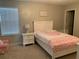 Bright bedroom features a bed, a nightstand with a lamp, and a window at 14841 Porter Rd, Winter Garden, FL 34787