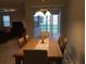 Elegant dining room with a wooden table, chandelier, and view of the screened patio and living room at 14841 Porter Rd, Winter Garden, FL 34787
