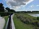 A scenic view of a tranquil lake with marshy edges, lush vegetation, and a sidewalk at 14841 Porter Rd, Winter Garden, FL 34787