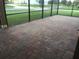 Screened patio featuring brick pavers, offering a comfortable and stylish outdoor living space overlooking the backyard at 14841 Porter Rd, Winter Garden, FL 34787