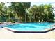 Community pool surrounded by lounge chairs and mature tropical landscaping at 1607 Northlake Dr # 1607, Sanford, FL 32773