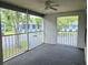 Screened porch featuring neutral carpet, ceiling fan, and views of the parking area and neighboring buildings at 1607 Northlake Dr # 1607, Sanford, FL 32773
