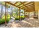 Covered back porch extends to a beautiful backyard with lush greenery and brick patio at 1617 Hontoon Rd, Deland, FL 32720