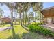 Picturesque backyard with palm trees, a stone fire pit, a well-kept lawn, and a charming covered porch at 1617 Hontoon Rd, Deland, FL 32720