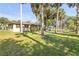 Expansive backyard featuring mature palms, a stone fire pit, a play set and plenty of green space at 1617 Hontoon Rd, Deland, FL 32720