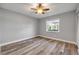Cozy bedroom featuring wood-look floors, ceiling fan, and bright window views at 1617 Hontoon Rd, Deland, FL 32720