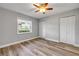 Comfortable bedroom featuring wood-look floors, ample closet space, and ceiling fan at 1617 Hontoon Rd, Deland, FL 32720