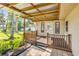 Charming covered patio area featuring brick flooring, wood rails, and a white door with glass panels at 1617 Hontoon Rd, Deland, FL 32720