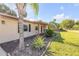 Close-up of a home's facade with a brick walkway and tropical plants lining the front entrance at 1617 Hontoon Rd, Deland, FL 32720
