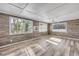 Inviting living room with stylish wood-look floors, three windows, and ceiling fan at 1617 Hontoon Rd, Deland, FL 32720