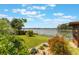 Lush backyard with a lake view, featuring a manicured lawn and colorful landscaping at 1802 Concert Rd, Deltona, FL 32738