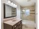 This well-lit bathroom features a large framed mirror and tiled shower and tub enclosure at 1802 Concert Rd, Deltona, FL 32738