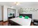 Well-lit bedroom with wood floors, modern ceiling fan, and tree wall art above the bed at 1802 Concert Rd, Deltona, FL 32738