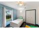 Cozy bedroom with dark wood floors, aqua accent wall, a single bed, and closet at 1802 Concert Rd, Deltona, FL 32738