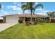 Charming single story home with a lush green lawn, mature palms, a brick facade and an attached two car garage at 1802 Concert Rd, Deltona, FL 32738