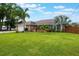 Charming single story home with a lush green lawn, mature palms, a brick facade and an attached two car garage at 1802 Concert Rd, Deltona, FL 32738