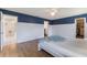 Spacious main bedroom featuring blue accent wall, wood-look flooring, and access to walk-in closet at 1802 Concert Rd, Deltona, FL 32738