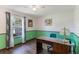 Home office with a stained wood desk, decorative green paint and natural light from a window at 1802 Concert Rd, Deltona, FL 32738