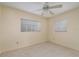 Minimalist bedroom featuring a ceiling fan, two windows offering natural light, neutral walls, and terrazzo flooring at 1821 Goodrich Ave, Winter Park, FL 32789