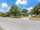 Well-maintained front yard with a mature tree, a long driveway, and partial view of the cozy home at 1821 Goodrich Ave, Winter Park, FL 32789