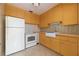Functional kitchen featuring bright yellow cabinetry, white appliances, and stylish tiled backsplash at 1821 Goodrich Ave, Winter Park, FL 32789