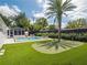 Expansive backyard with a pool, putting green, sauna, lounge chairs, outdoor dining set, and manicured landscaping at 2004 Mohawk Trl, Maitland, FL 32751