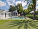 Backyard oasis with pool, putting green, outdoor dining area, and lush landscaping at 2004 Mohawk Trl, Maitland, FL 32751