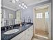 Bathroom with dual sinks, granite countertops, modern fixtures, and a glass door shower at 2004 Mohawk Trl, Maitland, FL 32751