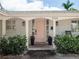 Close-up of a charming entrance featuring a pink front door, potted plants, and stylish exterior lighting at 2004 Mohawk Trl, Maitland, FL 32751