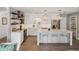 Modern white kitchen featuring an island with seating, marble countertops, and stainless steel appliances at 2004 Mohawk Trl, Maitland, FL 32751