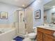 Bright bathroom featuring a tiled shower, tub, vanity, and a framed mirror over the sink at 2012 Gold Spring Cv, Kissimmee, FL 34743