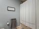 Bright bathroom area highlighting the clean white shower curtain and decorative wall art at 2012 Gold Spring Cv, Kissimmee, FL 34743