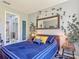 Comfortable bedroom with a blue bed, floral rug, an ensuite bathroom, and leafy plant decor at 2012 Gold Spring Cv, Kissimmee, FL 34743
